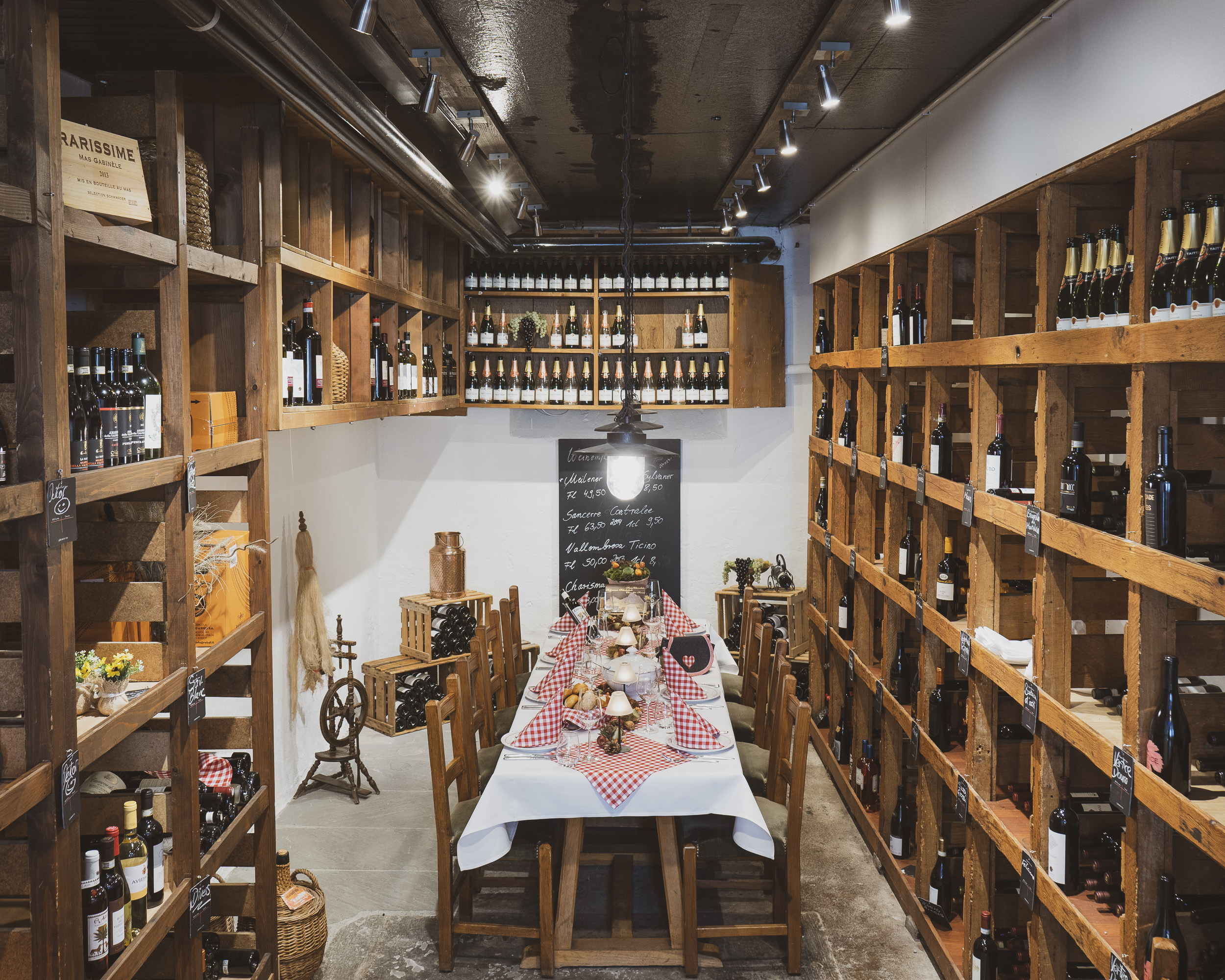 Der Weinkeller des Rössli Hurden mit deckenhohen gefüllten Weinregalen. In der Mitte ein gedeckter Tisch.